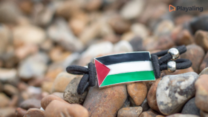 A Palestinian flag-bracelet laying among the rocks in a beach